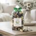 Irish Twins 'Cotton Fields' potpourri on wooden table. Cozy living room background with white sofa and cotton flowers. Fresh home fragrance.
